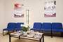 Miniatura de sala de espera con sillones azules, y mesa baja con plantas y revistas
